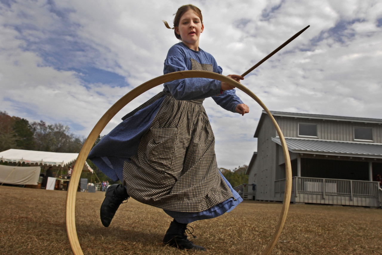 WILL DICKEY/The Times-Union--02/06/11--Meri Ivy Read, 12, plays with a hoop and stick during the Road to Olustee Living History Weekend at Camp Milton Historic Preserve Sunday, February 6, 2011 in Jacksonville, Florida.  (The Florida Times-Union, Will Dickey)